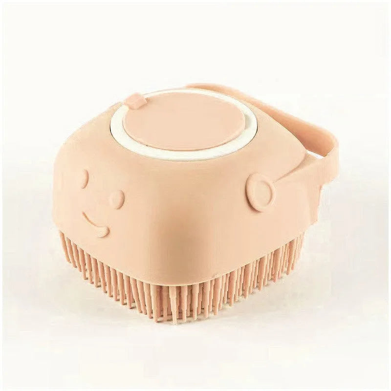 Peach-colored silicone scalp massager brush with soft bristles and a smiling face design