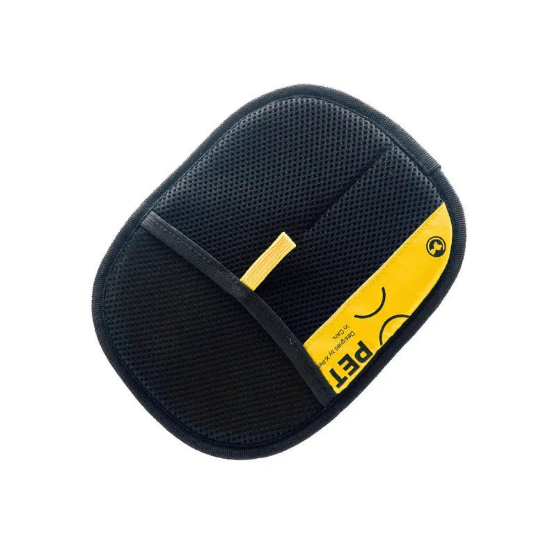 Black mesh pet grooming glove with yellow tag and adjustable wrist strap isolated on white